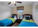 Twin bedroom with two beds, nightstand, and window at 3083 Yellow Lantana Ln, Kissimmee, FL 34747