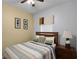 Cozy bedroom with striped bedding, ceiling fan, and wood furniture at 3083 Yellow Lantana Ln, Kissimmee, FL 34747