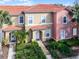 Two story tan and pink condo with a tiled roof and walkway at 3083 Yellow Lantana Ln, Kissimmee, FL 34747
