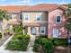 Two story tan and pink condo with a tiled roof and walkway at 3083 Yellow Lantana Ln, Kissimmee, FL 34747