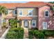 Two story tan and pink condo with a tiled roof and walkway at 3083 Yellow Lantana Ln, Kissimmee, FL 34747