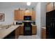 Kitchen features wood cabinets, black appliances, and a breakfast bar at 3083 Yellow Lantana Ln, Kissimmee, FL 34747