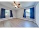 Bedroom with gray walls, wood-look flooring, and navy blue curtains at 309 Poinciana Cir, Kissimmee, FL 34744