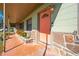 Covered porch with coral door and stone details at 309 Poinciana Cir, Kissimmee, FL 34744