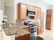 Modern kitchen with granite countertops and stainless steel appliances at 3252 Whooping Crane Run, Kissimmee, FL 34741