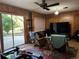 Living room with wood paneling, sliding glass doors, and a large TV at 3800 Lavender Way, Casselberry, FL 32707