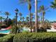 Tropical pool area with palm trees and red umbrellas at 467 La Mirage St, Davenport, FL 33897