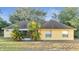 Rear view of a single-story yellow house with covered patio at 4814 Jeanette Ct, Saint Cloud, FL 34771