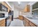 Bright kitchen with wood cabinets, black appliances, and tile floors at 4814 Jeanette Ct, Saint Cloud, FL 34771