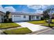 Front view of a single-story house with a white exterior and a spacious driveway at 5660 Minute Man Ct, Orlando, FL 32821