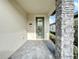 Front entrance with a green door and stone column at 7959 Delwin Ln, Kissimmee, FL 34747