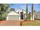 Charming two-story house with a gray garage door and neatly landscaped yard at 913 Cassia Dr, Davenport, FL 33897