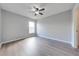 Spacious bedroom with wood-look flooring, a ceiling fan, and neutral gray paint at 1079 Berkeley Dr, Kissimmee, FL 34744