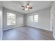 Spacious bedroom with wood laminate flooring, large windows, and neutral gray walls at 1079 Berkeley Dr, Kissimmee, FL 34744