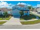 Front view of a blue two-story house with a driveway, garage, and landscaping at 1079 Berkeley Dr, Kissimmee, FL 34744