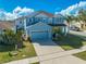 Front exterior of a two-story blue house with a driveway and attached garage at 1079 Berkeley Dr, Kissimmee, FL 34744