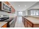 Bright kitchen featuring wood cabinetry, stainless steel appliances, and tile flooring at 1079 Berkeley Dr, Kissimmee, FL 34744