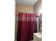 Bathroom with a burgundy shower curtain and white vanity at 116 S 4Th St, Haines City, FL 33844