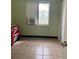 Small bedroom with a window and tile floors at 116 S 4Th St, Haines City, FL 33844
