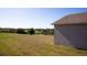 House side view, grassy yard, and distant water at 326 Dinner Lake Ct, Lake Wales, FL 33859