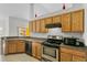Kitchen features wood cabinets, granite countertops, and stainless steel appliances at 3362 Winchester Estates Cir, Lakeland, FL 33810
