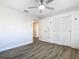 Bedroom with wood-look flooring, white closet doors, and ceiling fan at 666 Avenue B Sw, Winter Haven, FL 33880