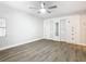 Bright bedroom with wood-look flooring, ceiling fan, and white built-in wardrobe with mirrored doors at 666 Avenue B Sw, Winter Haven, FL 33880