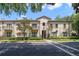 Tan two-story building with balconies, lush landscaping, and a tree-lined street at 701 Westpark Way # 202, Celebration, FL 34747