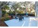 Spacious backyard patio with dining and seating areas under shade trees at 803 E 11Th Ave, New Smyrna Beach, FL 32169