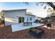 Modern backyard patio with dining area, fire pit, and wood chips at 803 E 11Th Ave, New Smyrna Beach, FL 32169