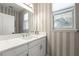 Elegant bathroom with white vanity and striped wallpaper at 9111 Outlook Rock Trl, Windermere, FL 34786