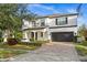 Two-story house with a white exterior, black accents, and a paved driveway at 9111 Outlook Rock Trl, Windermere, FL 34786