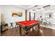 Game room with red pool table, hardwood floors, and view into dining area at 9111 Outlook Rock Trl, Windermere, FL 34786
