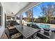 Outdoor dining area with wooden table and chairs overlooking the pool at 9111 Outlook Rock Trl, Windermere, FL 34786