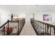 Upstairs hallway with elegant railing and hardwood floors at 9111 Outlook Rock Trl, Windermere, FL 34786