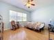 Relaxing bedroom with wood floors, ceiling fan, and rocking chairs at 105 Flame Vine Way, Groveland, FL 34736