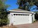 White two-car garage with black accents and a brick paved driveway at 1493 Park Dr, Casselberry, FL 32707