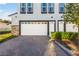 Modern townhome with a white garage door and a brick paved driveway at 1800 Houston St, Kissimmee, FL 34743