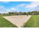 Sand volleyball court with net and surrounding green space at 1869 Brockridge Rd, Kissimmee, FL 34744