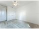 Empty, spacious bedroom with double doors, gray carpet, white walls, and a ceiling fan at 234 Mosaic Blvd, Daytona Beach, FL 32124