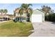 Green two-story house with attached garage and palm tree at 2545 Harris Blvd, Kissimmee, FL 34746