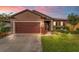 Attractive one-story house with brown garage door and landscaped lawn at 3907 Baja Dr, St Cloud, FL 34772