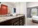 Bathroom vanity with dark wood cabinets, granite countertop, and double sinks at 4141 Lana Ave, Davenport, FL 33897