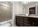 Guest bathroom with dark wood cabinetry, granite countertops, and sliding glass shower doors at 4141 Lana Ave, Davenport, FL 33897