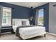 Modern bedroom with stylish lighting, blue-gray walls, and white bedding at 4141 Lana Ave, Davenport, FL 33897