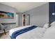 Modern bedroom with workspace, blue accent wall, comfortable bed, and TV at 4141 Lana Ave, Davenport, FL 33897
