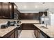 Modern kitchen featuring dark wood cabinetry, granite countertops, and stainless steel appliances at 4141 Lana Ave, Davenport, FL 33897
