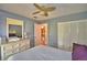 Bedroom with white dresser, ceiling fan, and large closet doors at 458 Hunter Cir, Kissimmee, FL 34758