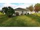 Back of tan house with lush green lawn and landscaping at 504 Ridge View Dr, Davenport, FL 33837