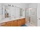 Bathroom with double vanity, large mirror, and shower at 543 Birkdale St, Davenport, FL 33897